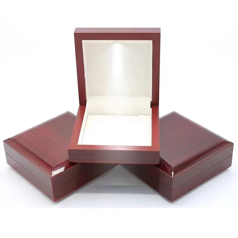 Red wooden jewelry gift box, bright LED spotlight inside the lid